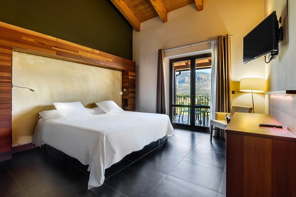 Guest room at Hotel Agua de los Mallos with balcony and views towards the Mallos de Riglos